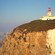A lighthouse on a cliff that overlooks the ocean